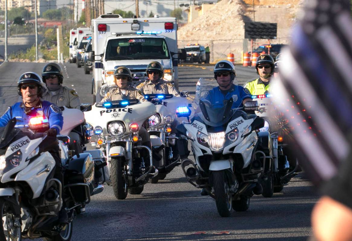 An ambulance carrying wounded Las Vegas police officer Shay Mikalonis is seen during a processi ...