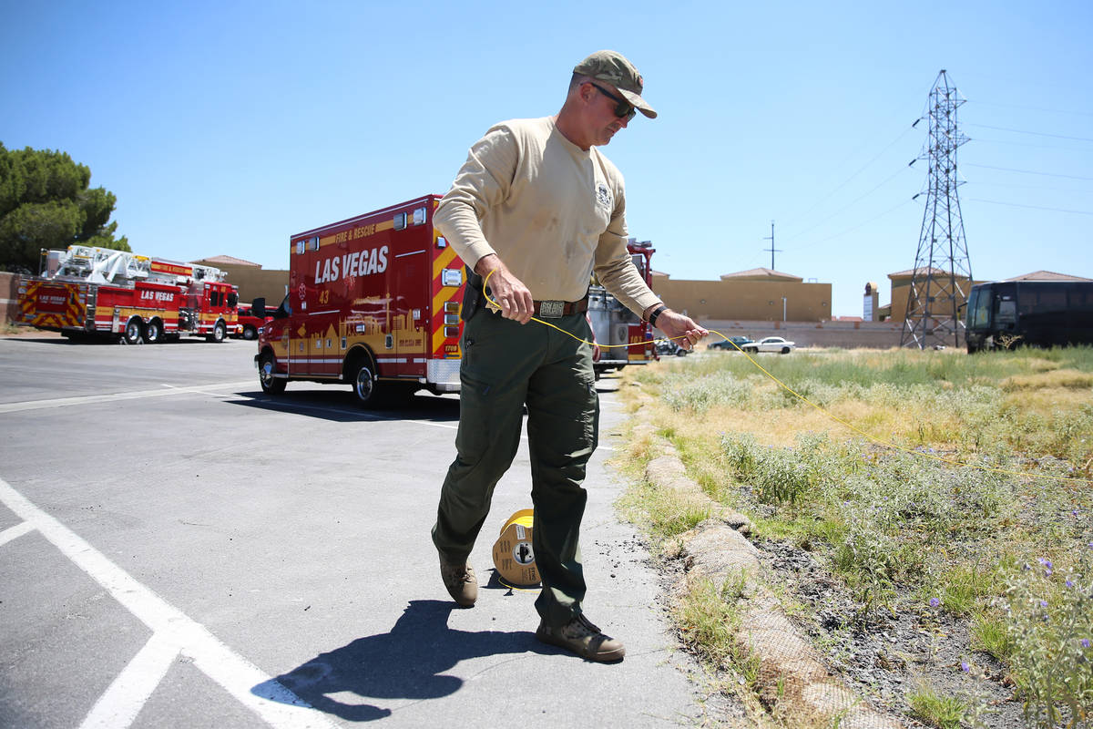 Mark Duncan, bomb squad technician with Las Vegas Fire and Rescue, sets up a charge to blow up ...