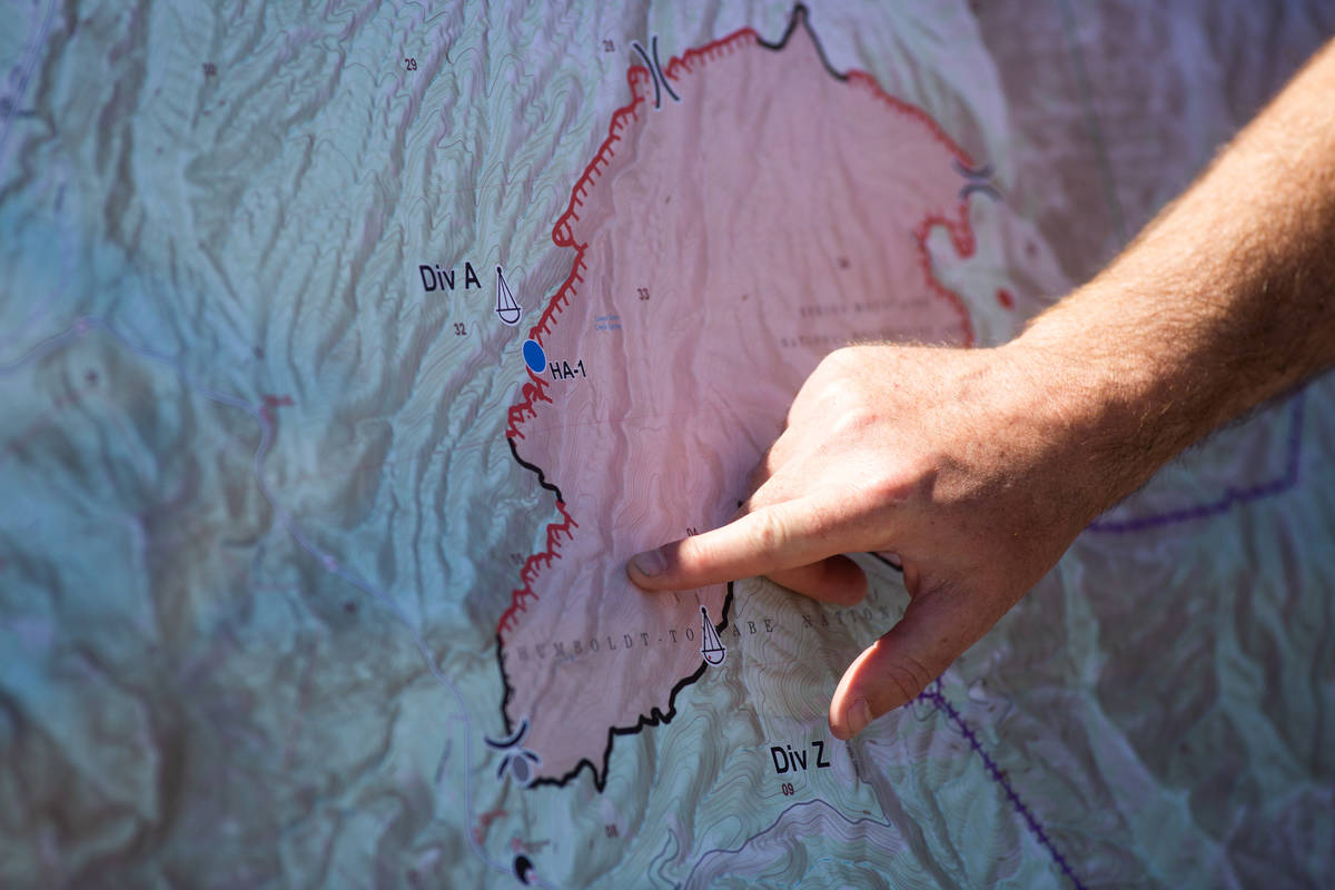 Jeremy Kiesling, the incident commander trainee with Great Basin Team 7, points to a map of the ...
