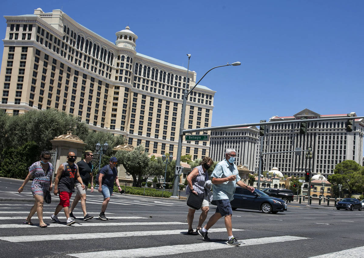 Tourists cross Las Vegas Boulevard near the Bellagio on Friday, July 3, 2020, in Las Vegas. (Bi ...