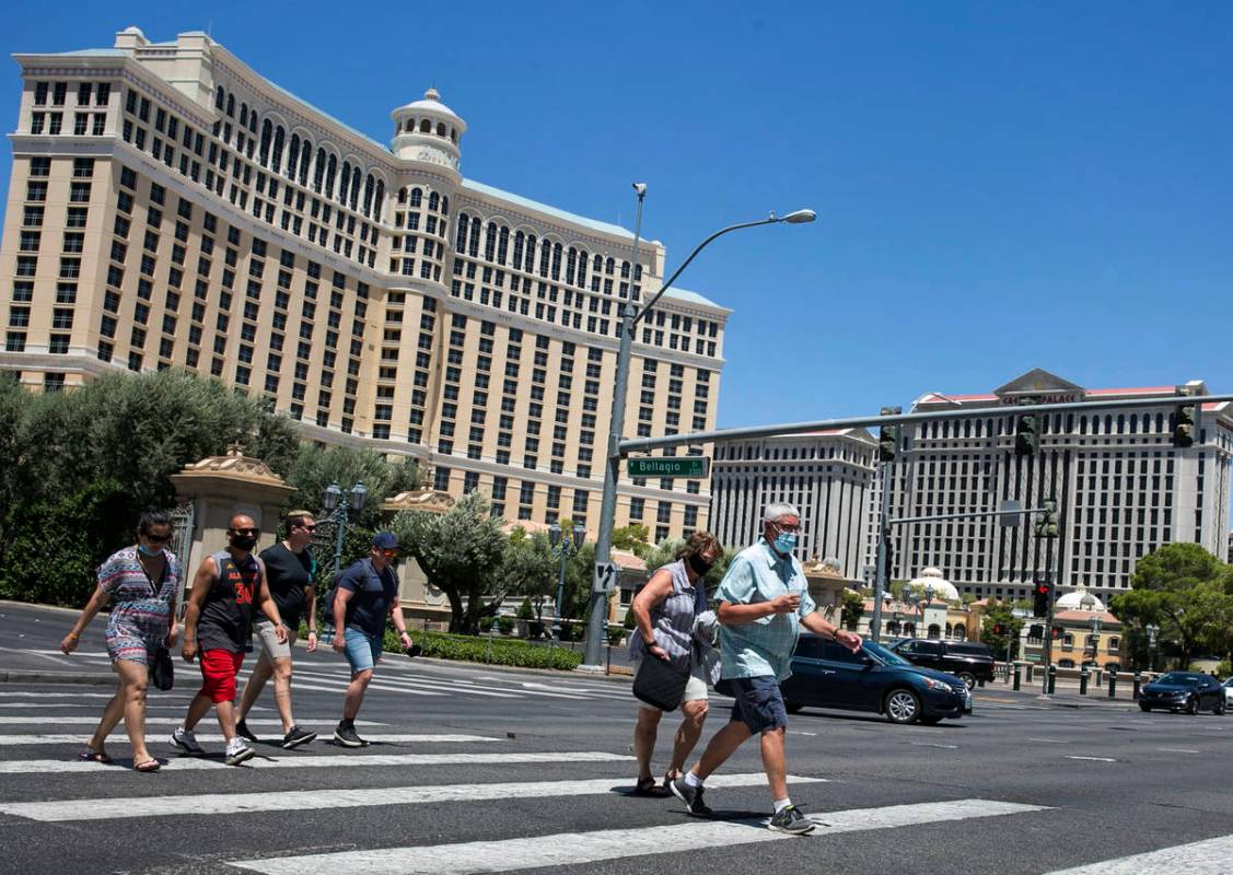 Tourists cross Las Vegas Boulevard near the Bellagio on Friday, July 3, 2020, in Las Vegas. (Bi ...