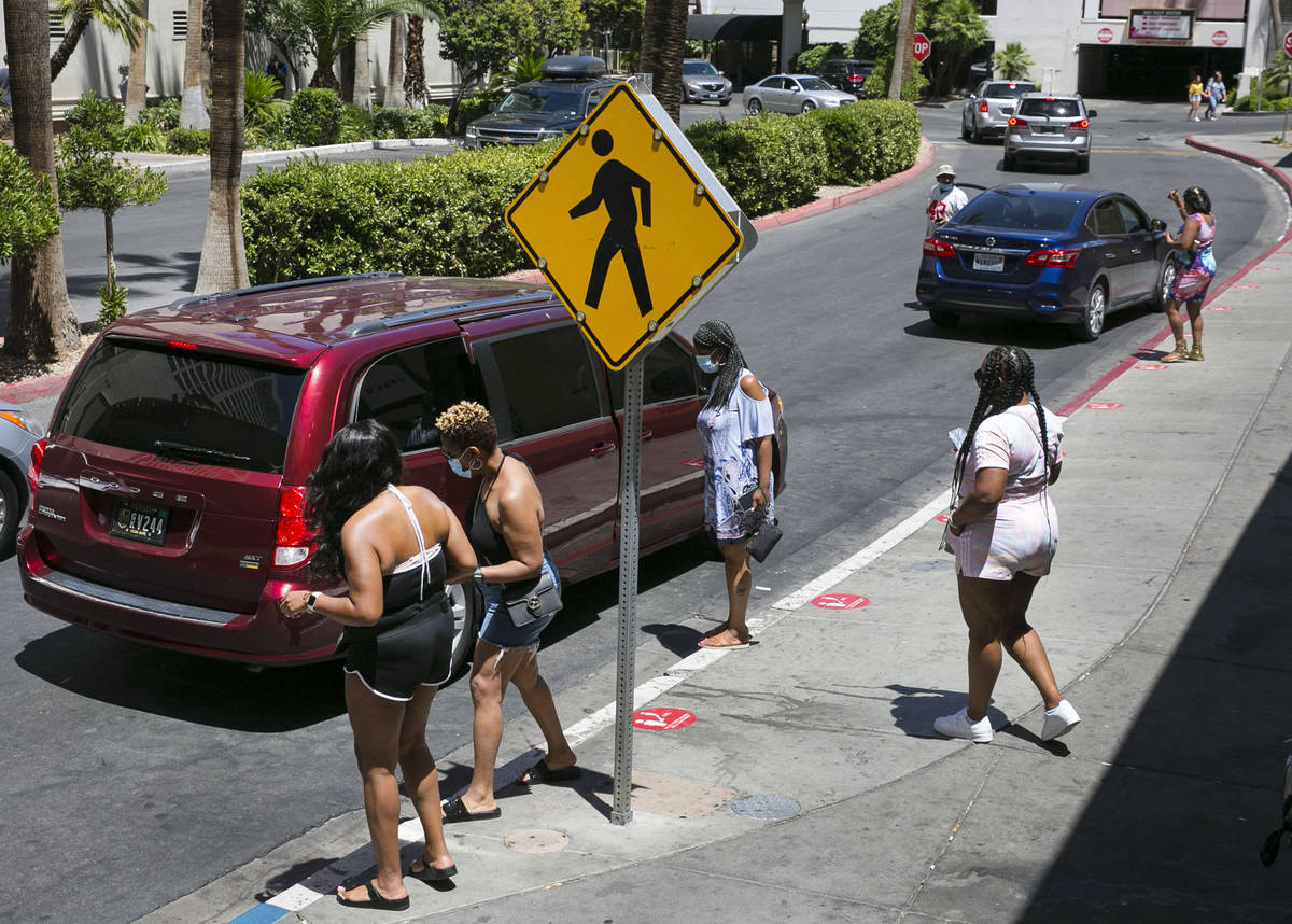 Tourists wait for their ride at ride sharing pick up area outside of the Flamingo on Friday, Ju ...