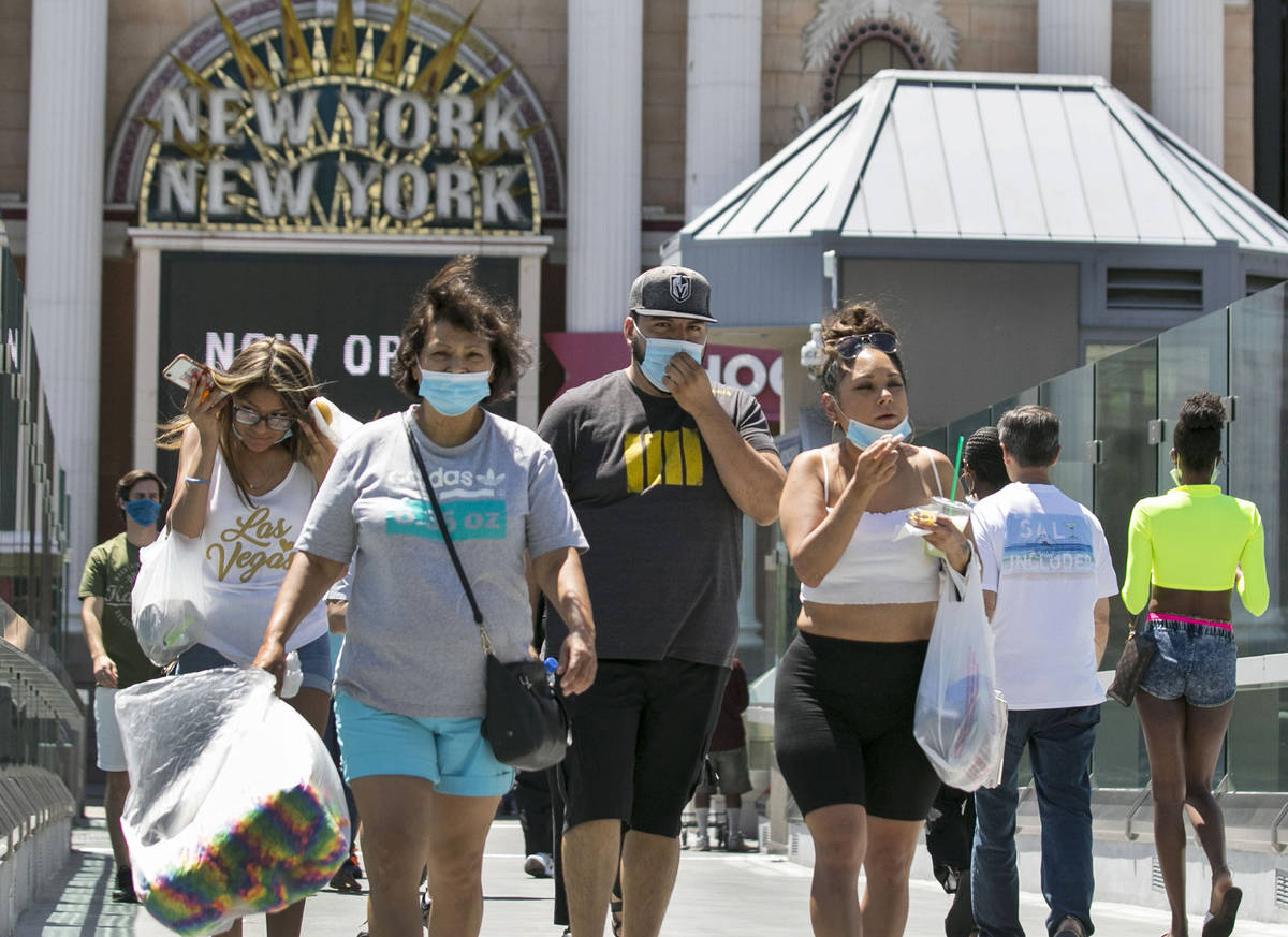 Tourists walk on the pedestrian bridge between New York-New York and the MGM Grand on Friday, J ...