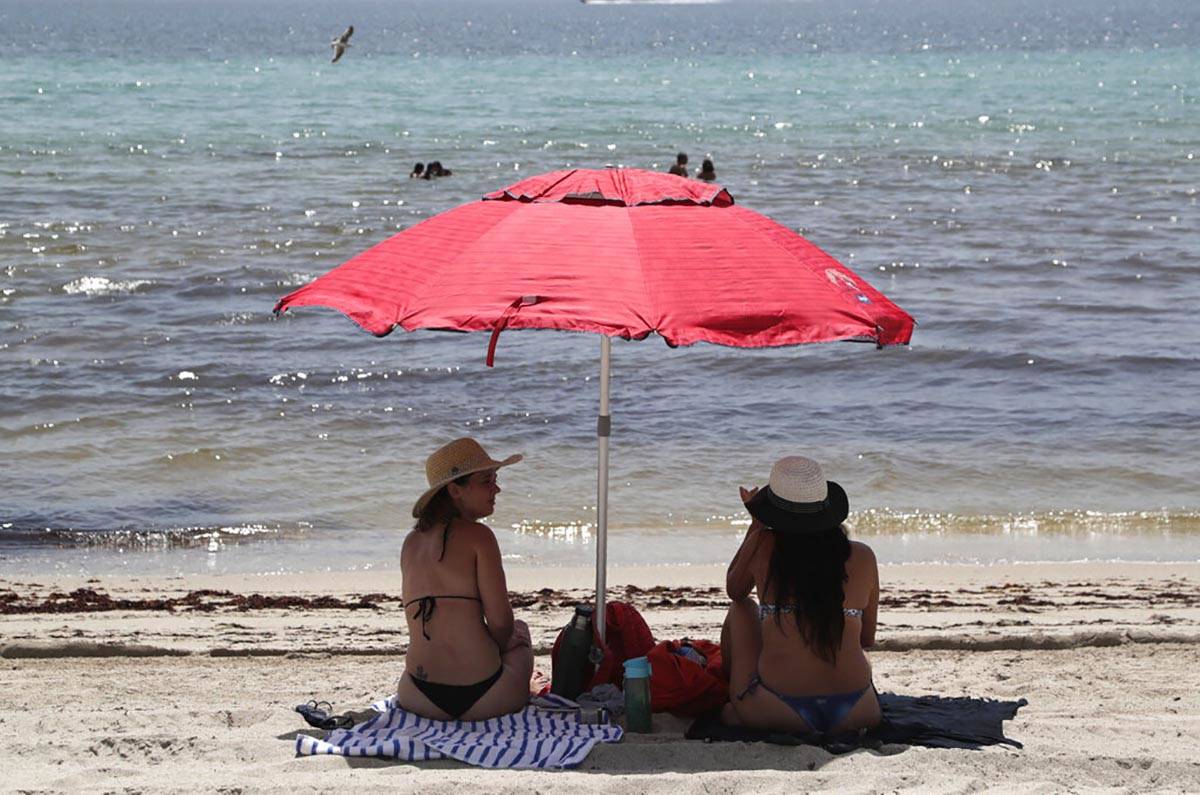 People sit on Hollywood Beach during the new coronavirus pandemic, Thursday, July 2, 2020, in H ...