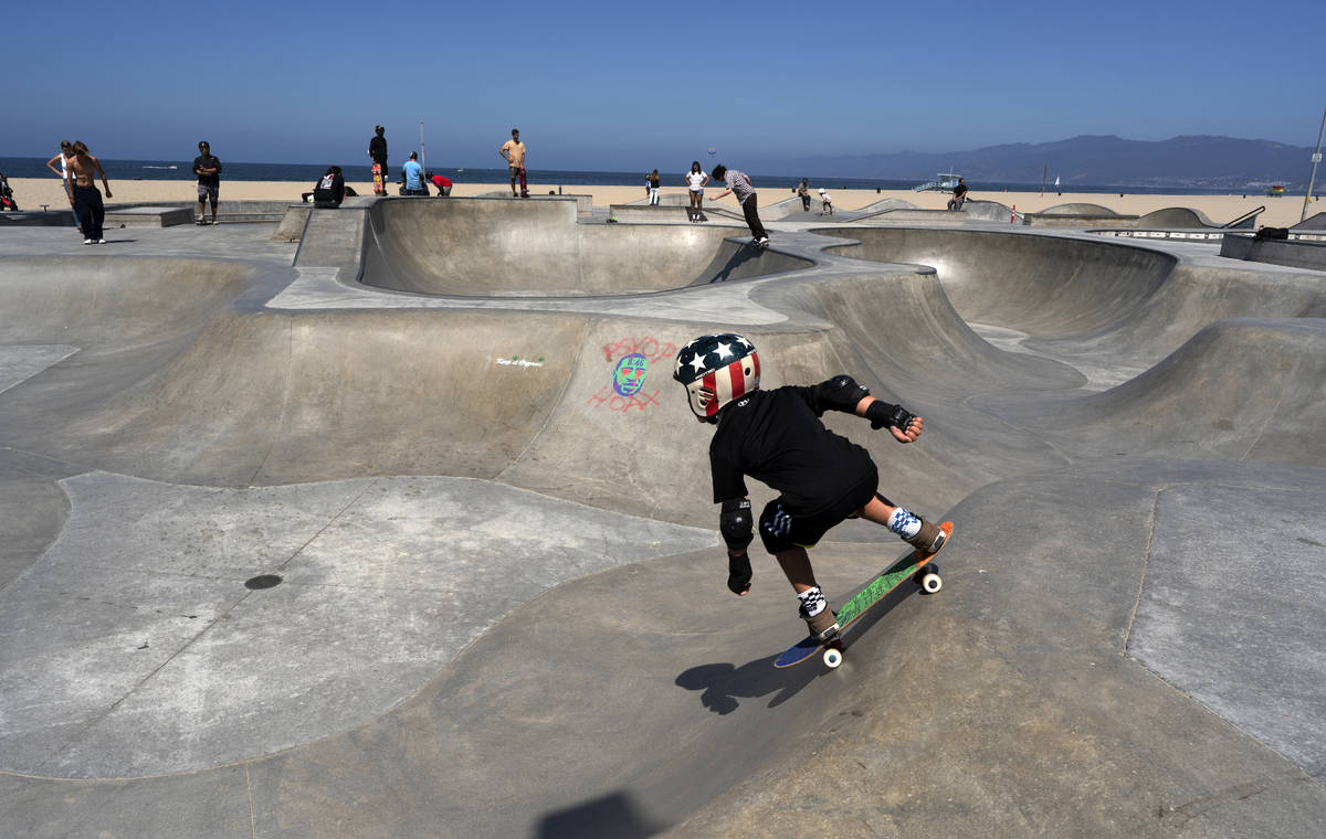 A young skateboarder takes a run at a sparsely crowded Venice beach skateboard park ahead of th ...