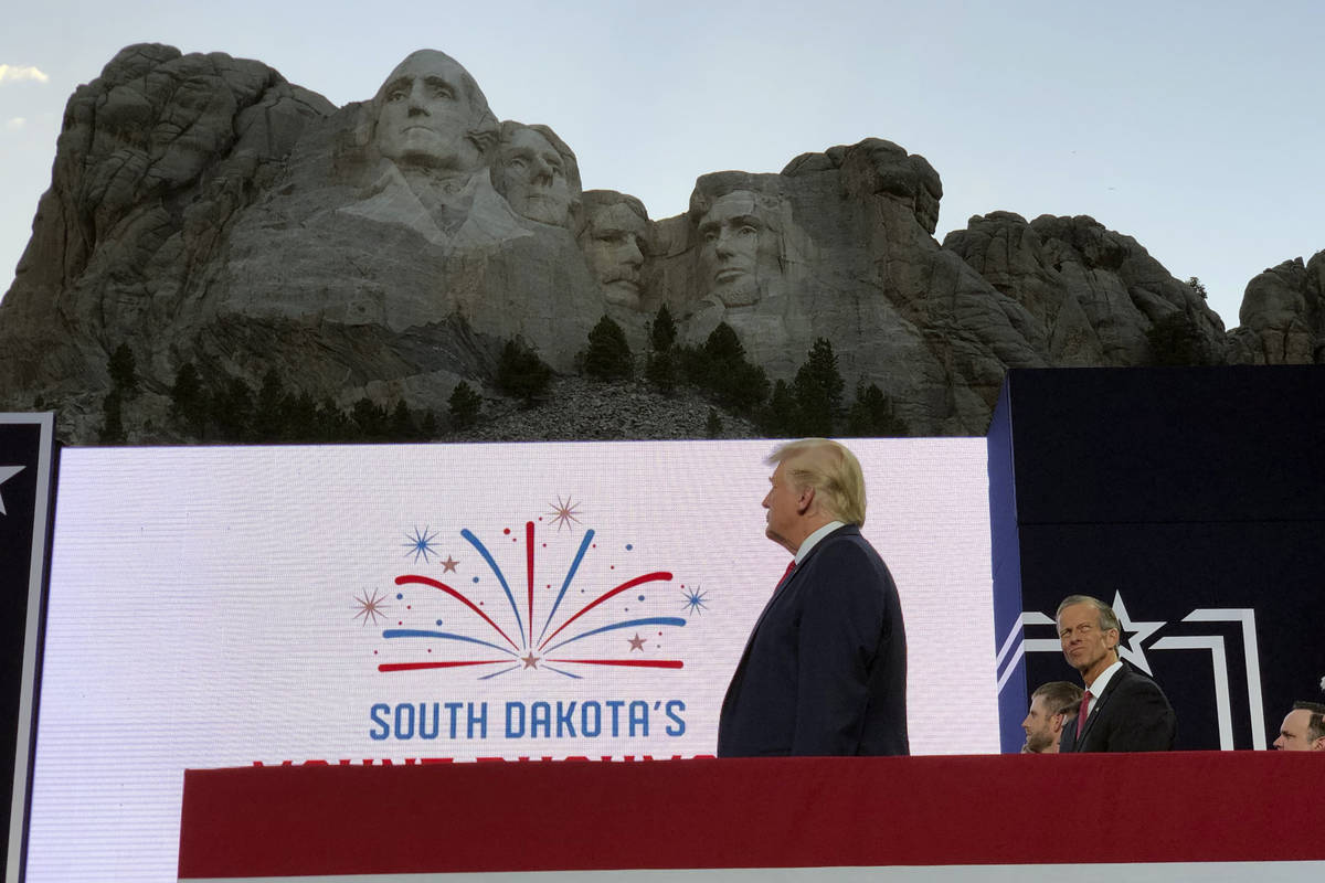 President Donald Trump stands on stage before he speaks at the Mount Rushmore National Monument ...