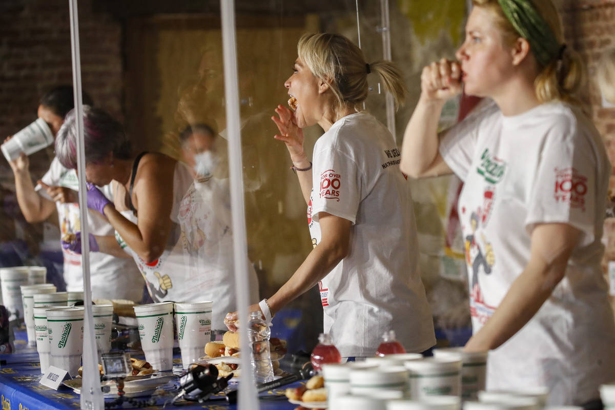 Competitive eater Miki Sudo, second right, eats a women's world record of 48 and a half hot dog ...