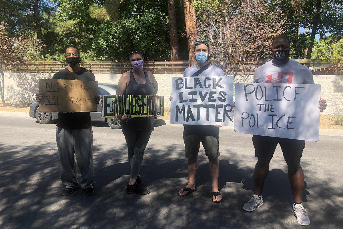 Kenny Fawkes and Sam McKellar, standing to the left, pose with other protesters in Las Vegas Ma ...