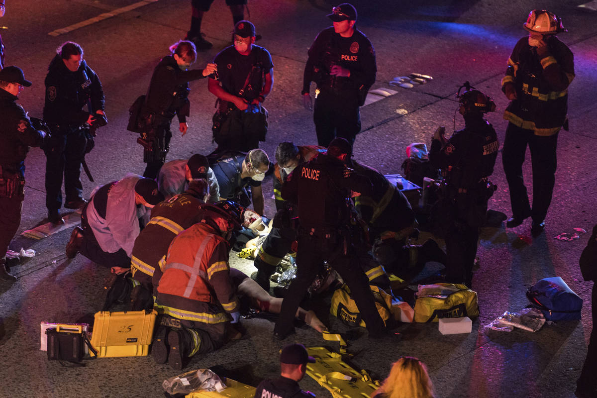 Emergency workers tend to an injured person on the ground after a driver sped through a protest ...