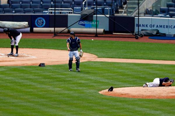 New York Yankees pitcher Masahiro Tanaka lies on the field after being hit by a ball off the ba ...