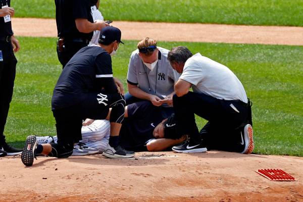 New York Yankees pitcher Masahiro Tanaka lies on the field after being hit by a ball off the ba ...