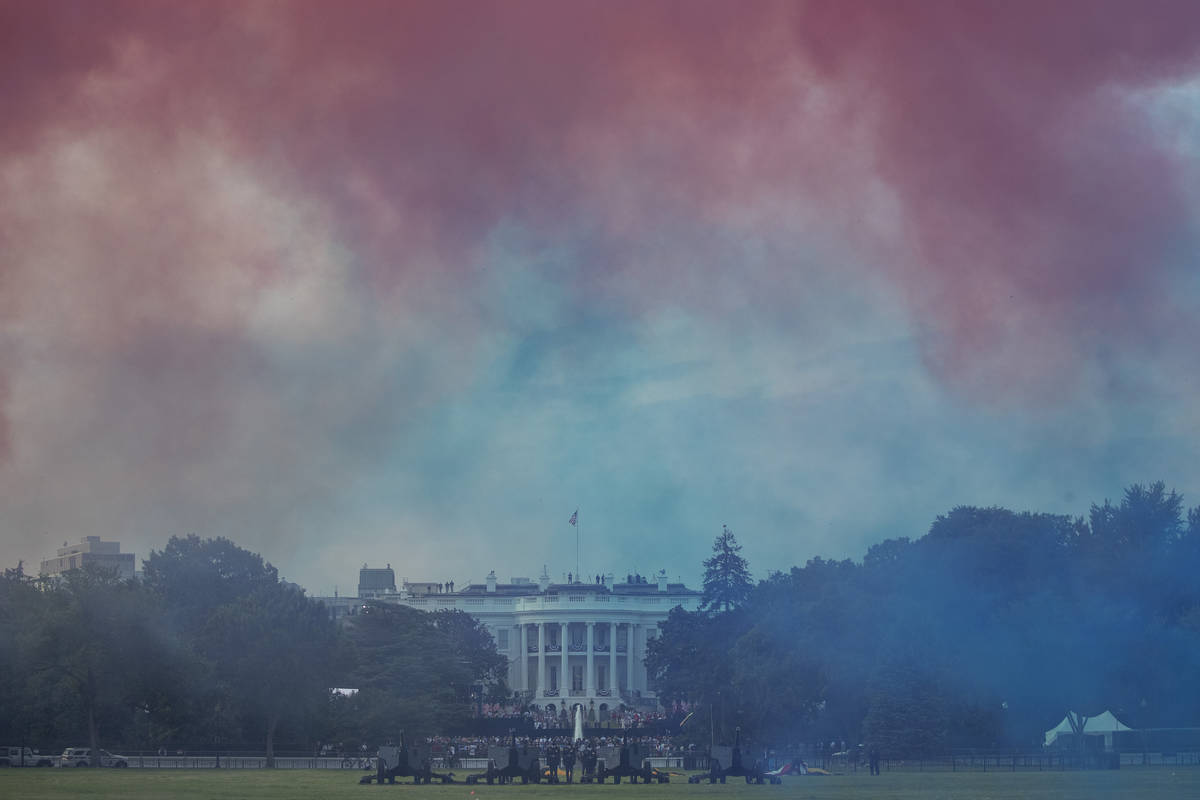 The White House in obscured by Red and Blue smoke floating on the Ellipse during a "Salute ...