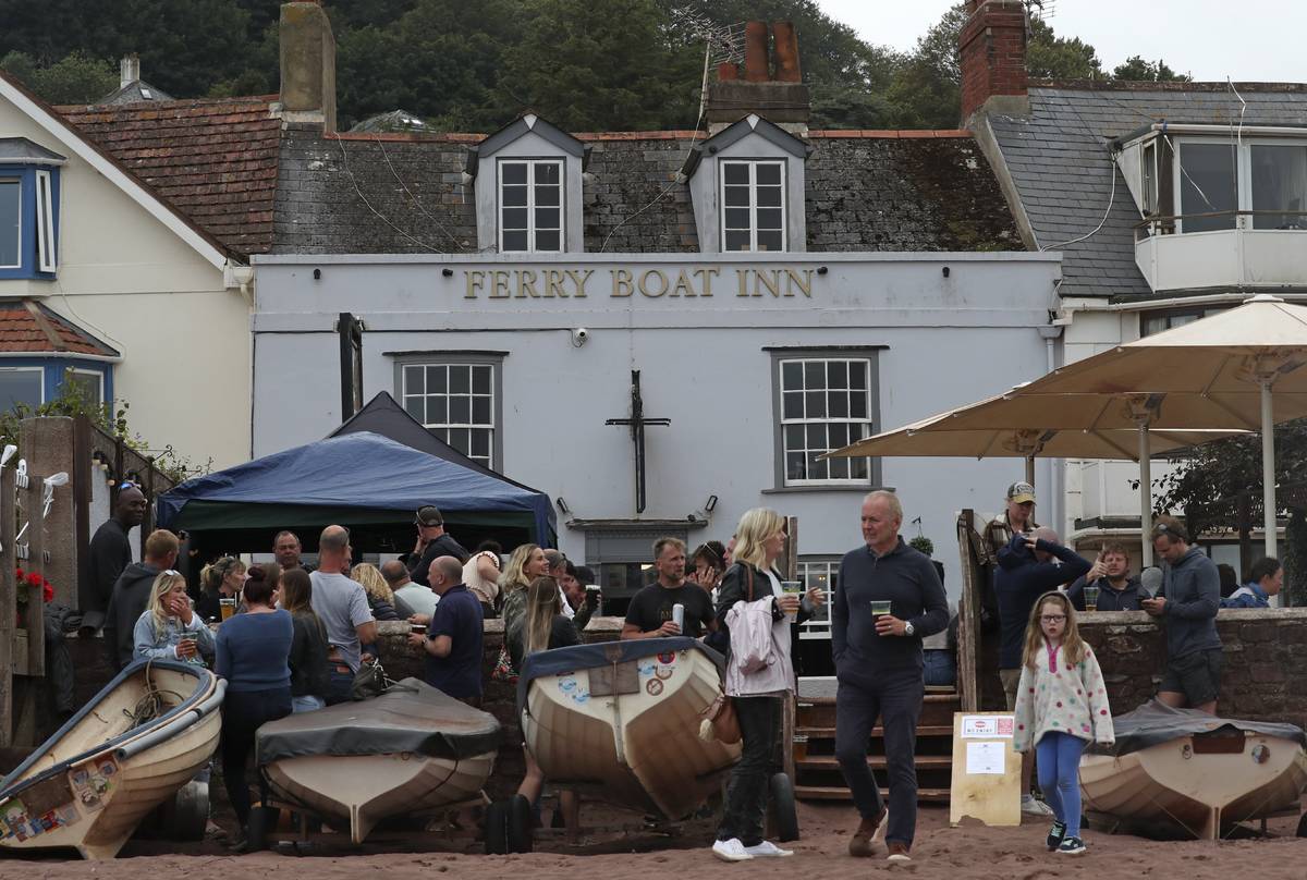 People enjoy a drink outside the Ferry Boat Inn in Shaldon, England, Saturday, July 4, 2020. En ...