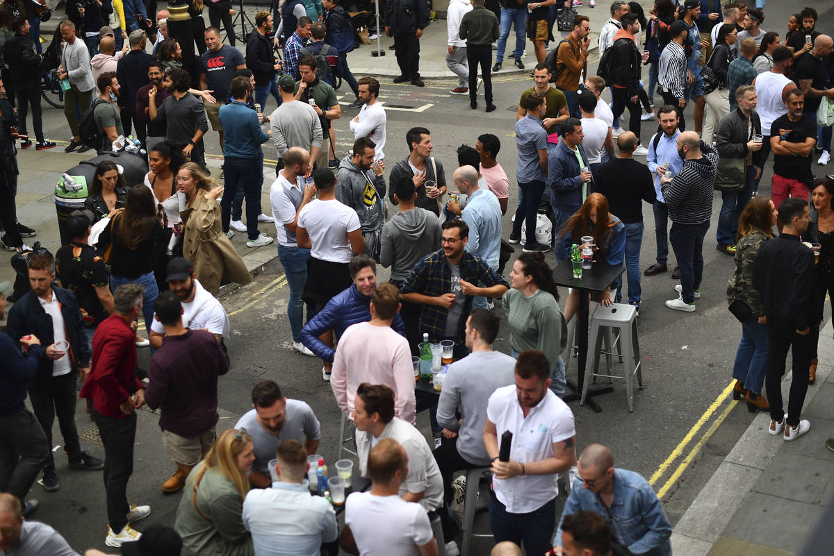 Drinkers in Soho congregate, as coronavirus lockdown restrictions eased across England, in Lond ...
