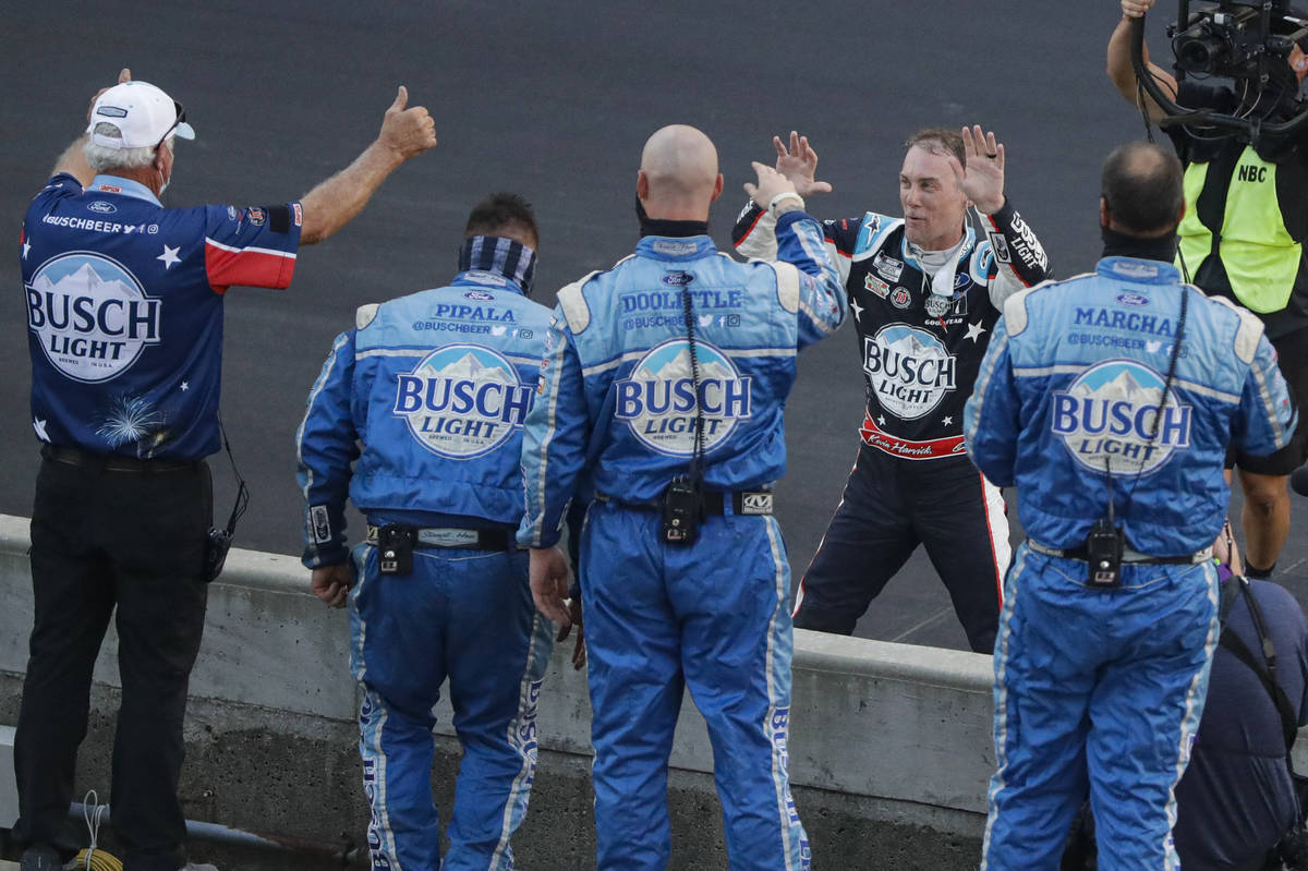 Kevin Harvick, on far side of wall, celebrates with his crew after winning the NASCAR Cup Serie ...