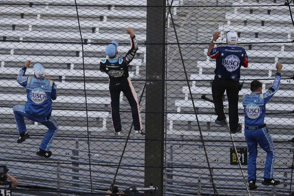 Kevin Harvick, second from left, and some members of the team's crew climb the fence after Harv ...