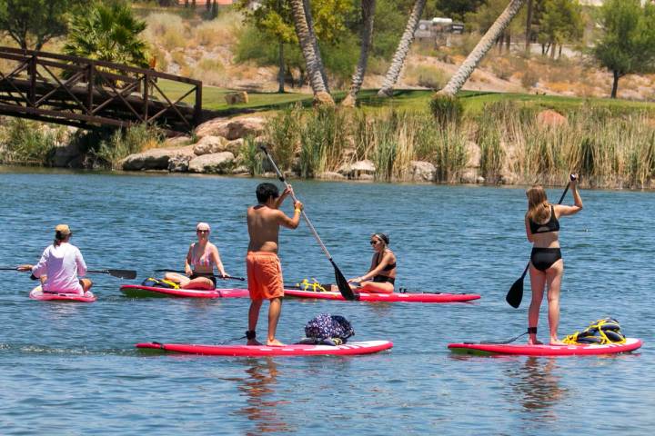 People take advantage of the hot weather to enjoy paddle boarding at Lake Las Vegas on Monday, ...