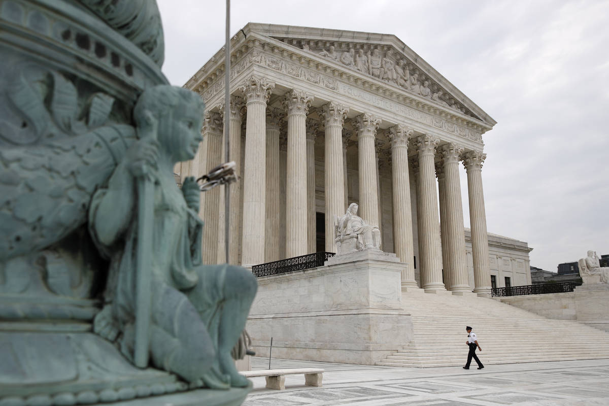 A police officer walks outside the Supreme Court on Capitol Hill in Washington, Monday, July 6, ...