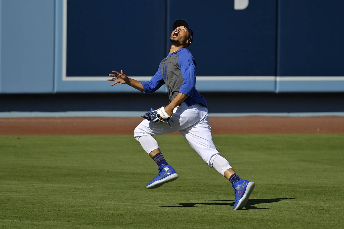Los Angeles Dodgers right fielder Mookie Betts fields a fly ball during the restart of baseball ...