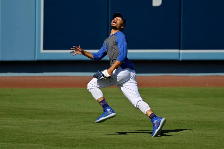 Los Angeles Dodgers right fielder Mookie Betts fields a fly ball during the restart of baseball ...