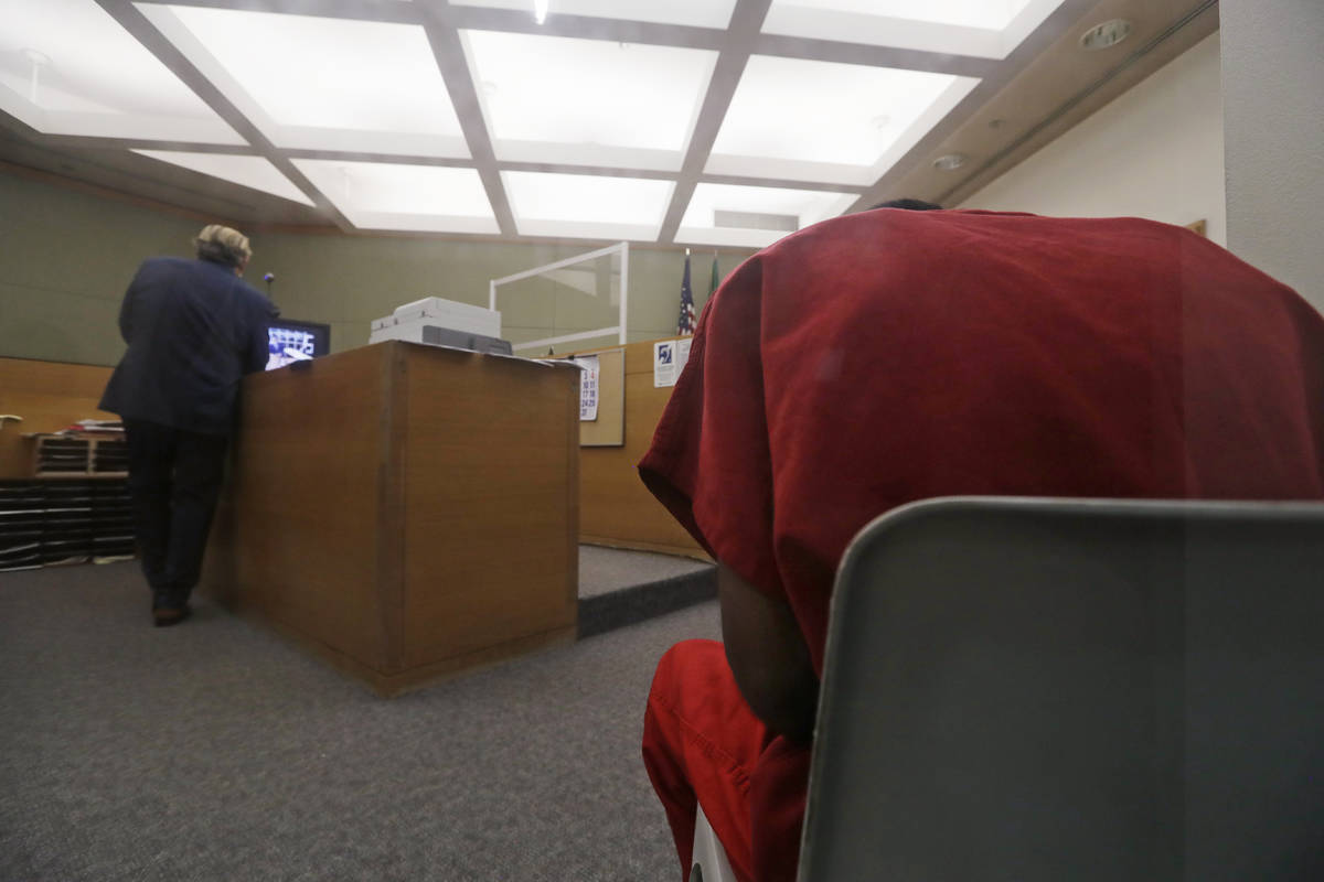 Attorney John Henry Browne, left, stands in view of a video feed as his client Dawit Kelete sit ...