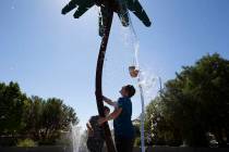 Carlos Contreras, left, 9, and his brother Edwin Contreras, right, 11, wait for water to fall f ...