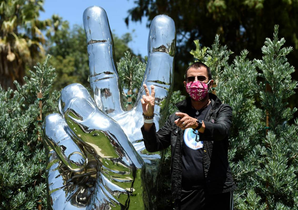 Musician Ringo Starr poses in front of his "Peace and Love" sculpture on his 80th bir ...