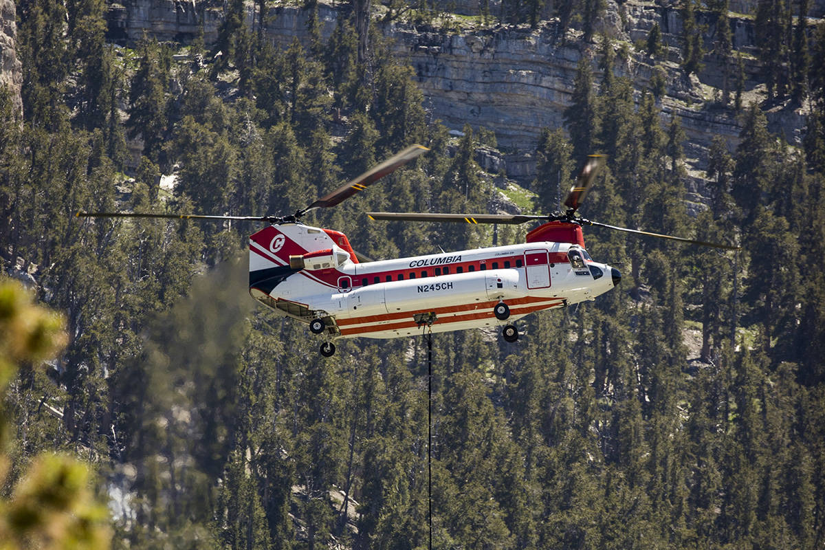 A helicopter with water bucket fills up at the Lee Canyon Ski Resort for another drop over the ...