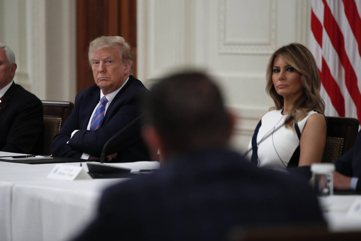 President Donald Trump and first lady Melania Trump listen during a "National Dialogue on ...