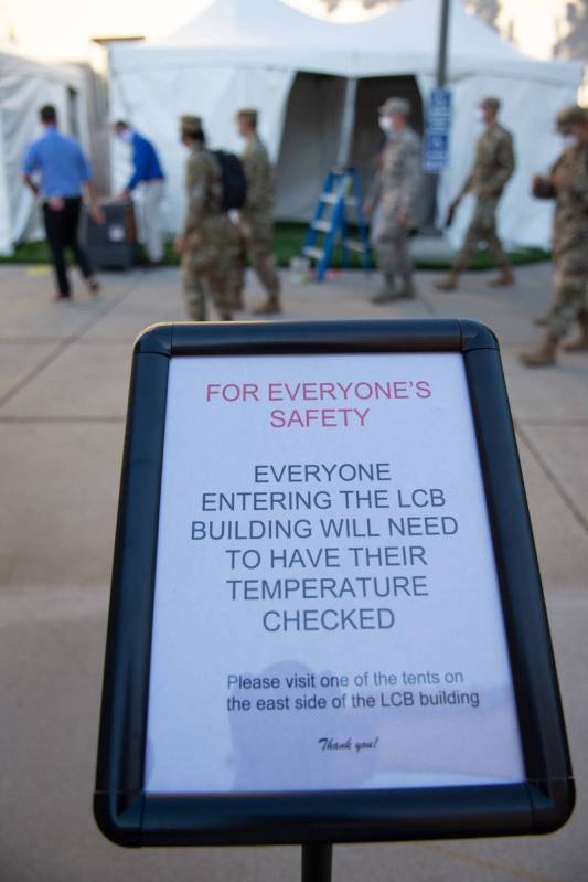 A sign outside the Nevada Legislature in Carson City announcing temperature checks before the f ...