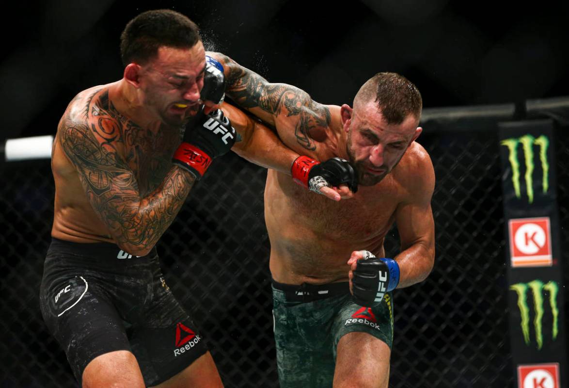 Max Holloway, left, fights Alexander Volkanovski during their featherweight title boutÊin UFC ...