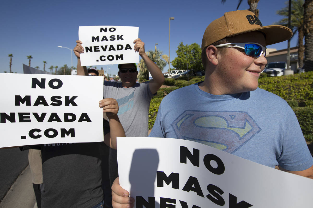 James Thiriot, right, 15, participates in the "No Mask Protest" at the intersection o ...
