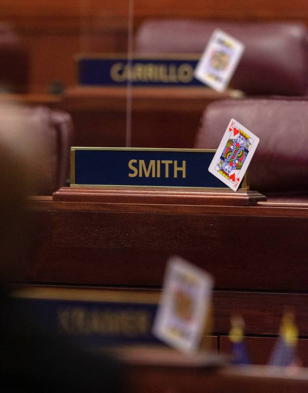 In order to maintain social distancing, oversized playing cards mark unused desks inside the As ...