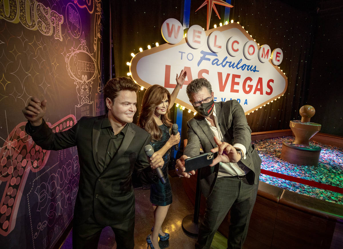 John Katsilometes poses with Donny & Marie during a tour of Madame Tussauds Las Vegas wax m ...