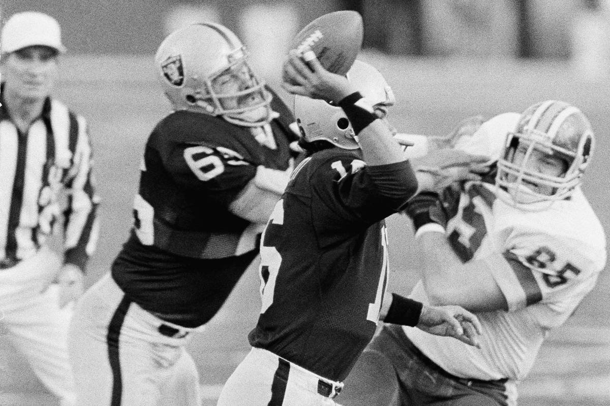 Los Angeles Raiders quarterback Jim Plunkett prepares to pass under pressure as Washington Reds ...