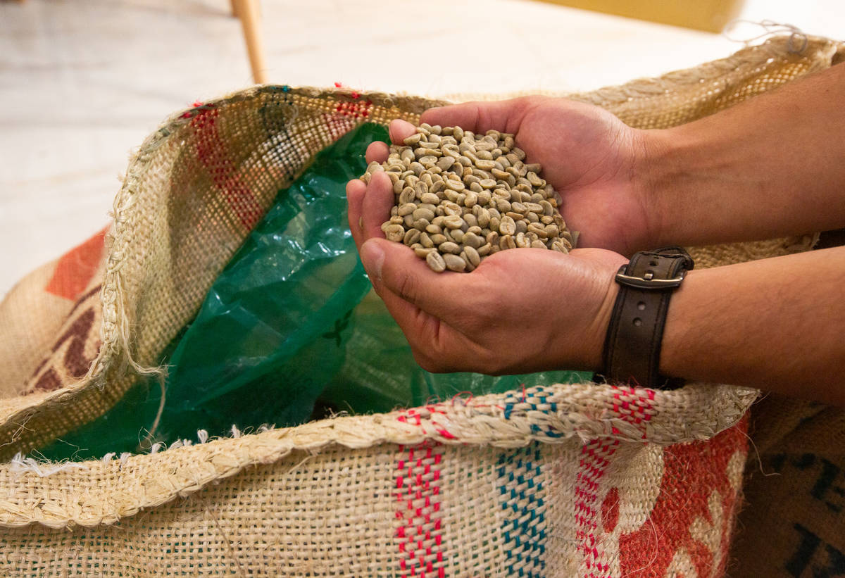 Josh Molina, the owner of Take It Easy, shows one of the types of coffee beans used in the coff ...