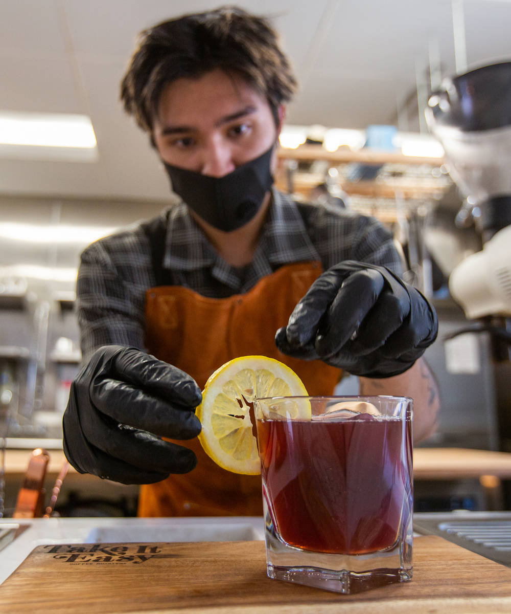 Erik Kelley, a barista at Take It Easy, adds a lemon wheel to the On the Block drink in Las Veg ...