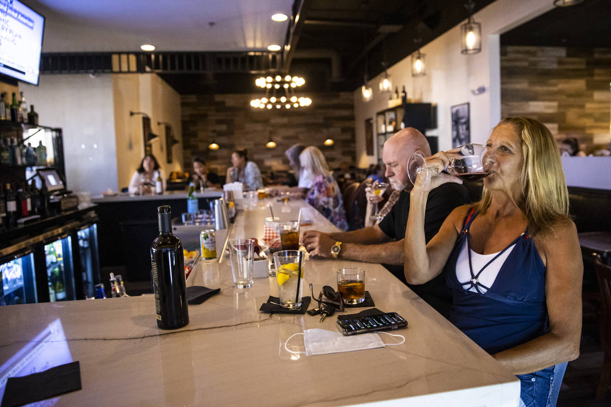 Marti Taylor, of Las Vegas, enjoys a glass of wine during happy hour at Spaghetty Western in th ...
