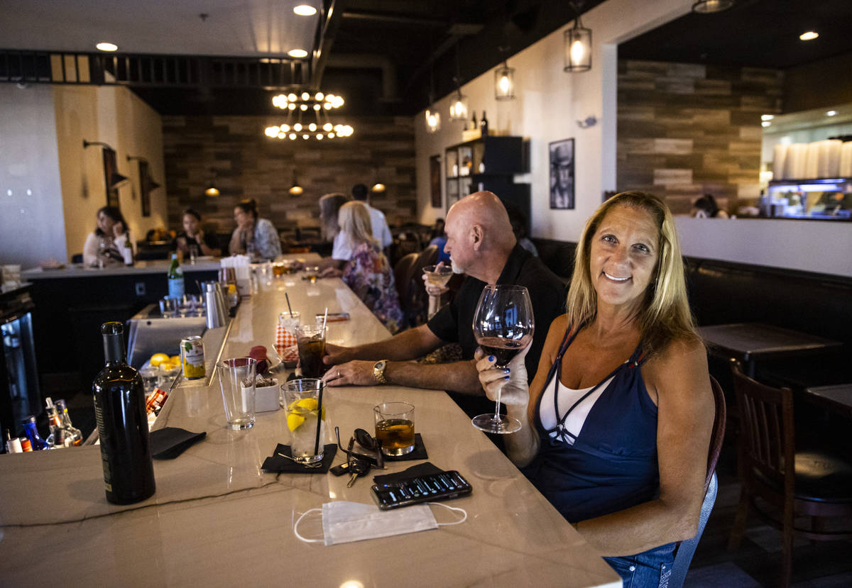 Marti Taylor, of Las Vegas, enjoys a glass of wine along with a cocktail during happy hour at S ...