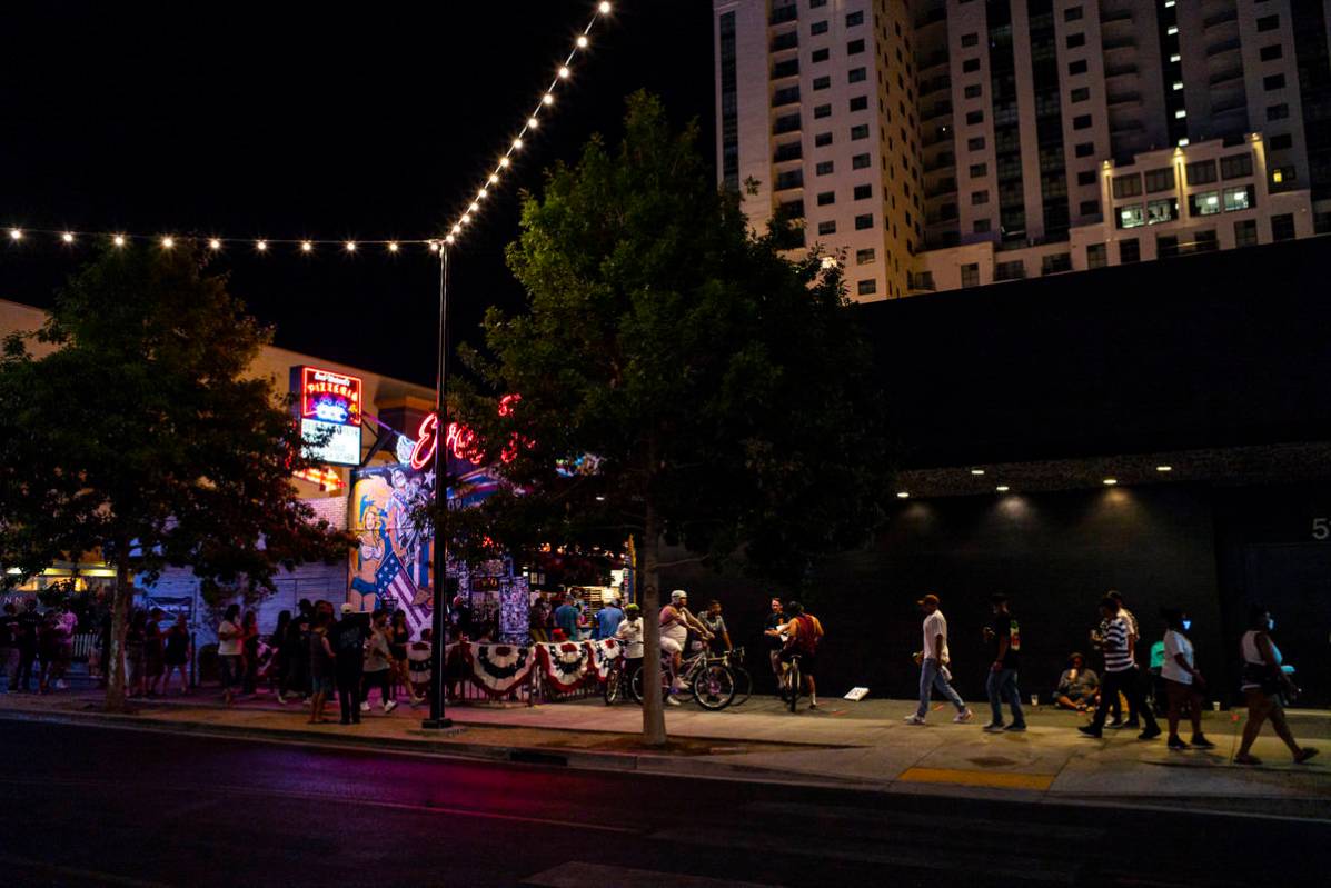 People crowd Fremont Street just after midnight in downtown Las Vegas as bars shut down in Clar ...