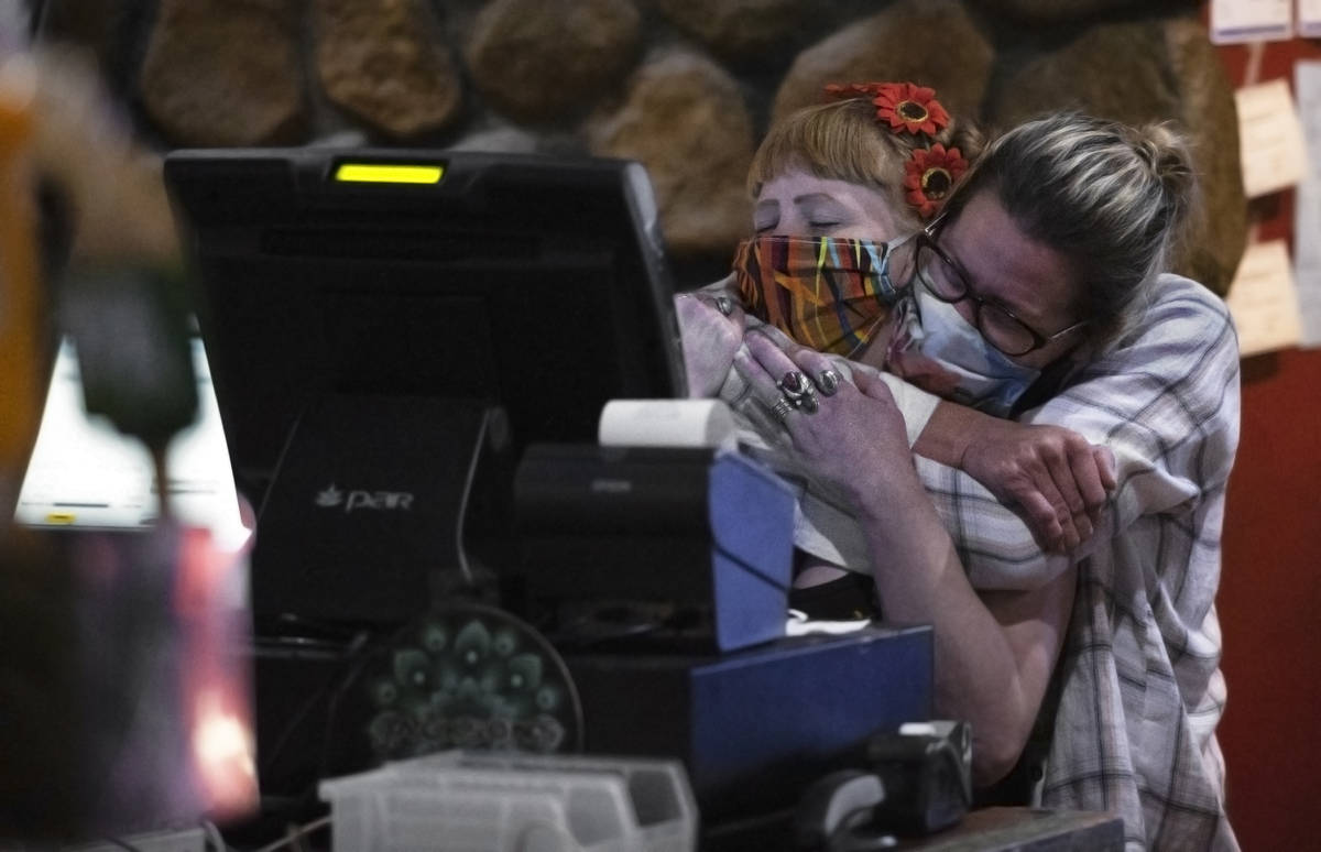 Bartenders Teah Heath, left, and Dawn Smith share a hug minutes before last call at Jackson&#x2 ...