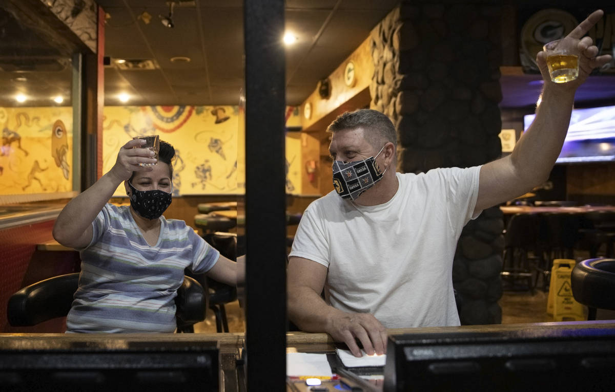 John Adler, right, and Norma Jean Aguilar lift their glasses during a last call toast at Jackso ...