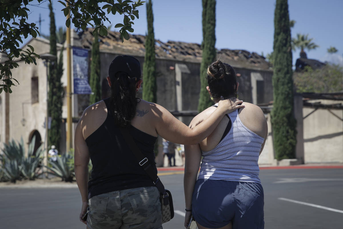 Selena Quezada, right, and her mother Cathy stand outside the fire-damaged San Gabriel Mission, ...