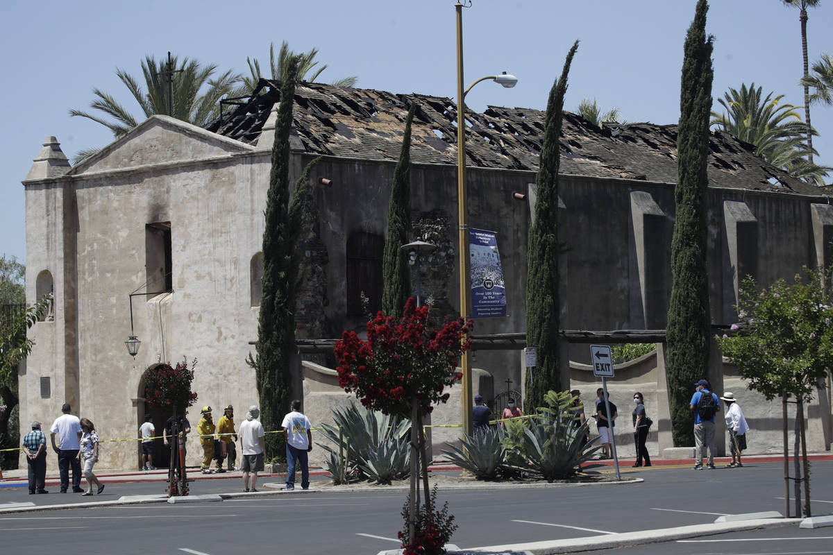 Curious onlookers stand outside the San Gabriel Mission in the aftermath of a morning fire Satu ...