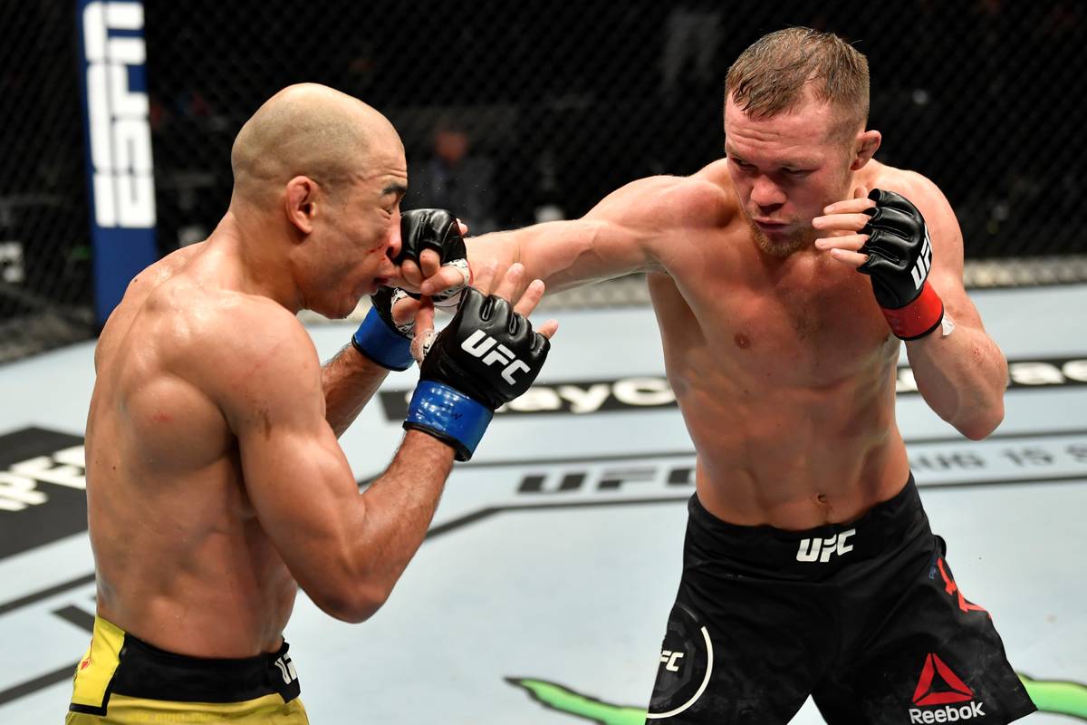 Petr Yan of Russia punches Jose Aldo of Brazil in their UFC bantamweight championship fight dur ...