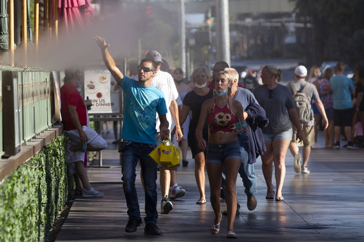 Pedestrians feel mist from HEXX kitchen + bar's patio as temperatures peaked to 113 degrees on ...