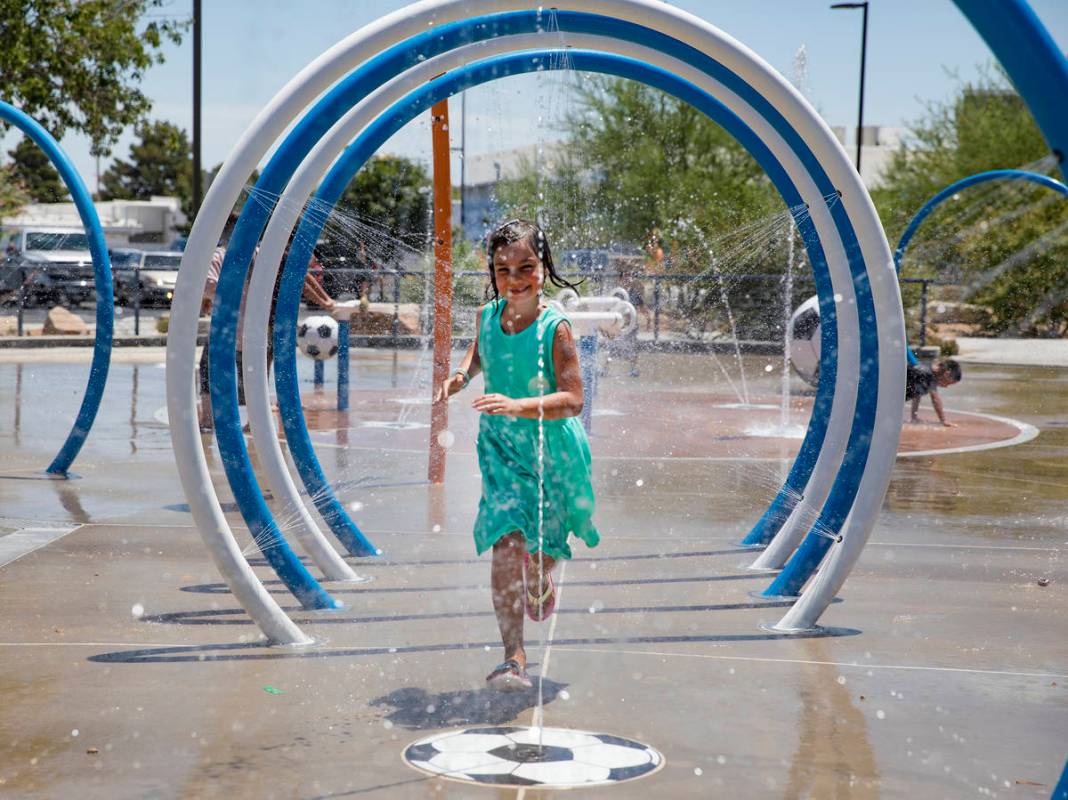 Myriah Vernoy, 8, runs through a water tunnel at Baker Park in Las Vegas, Sunday, July 12, 2020 ...