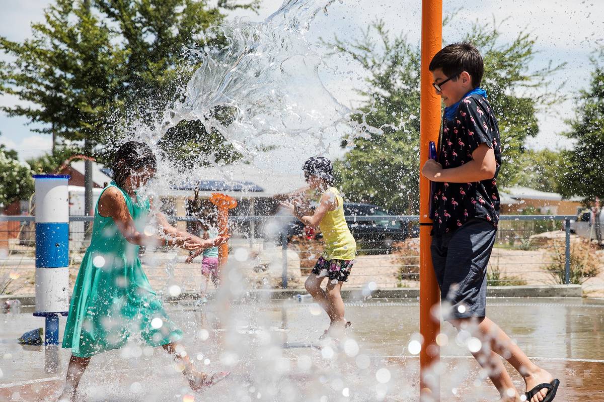 Myriah Vernoy, 8, left, plays with her brother Elysha Vernoy, 14, right, at Baker Park in Las V ...