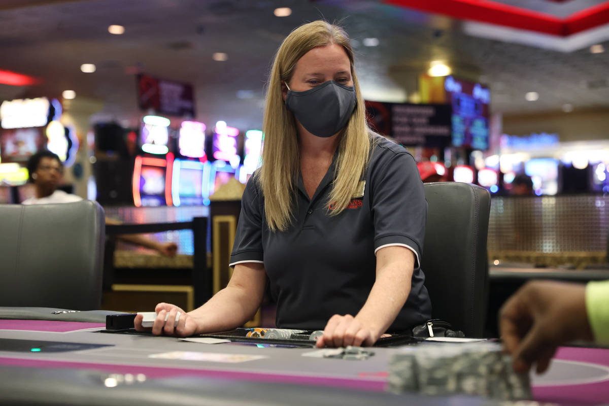 Dealer Joey Pike works a poker table during the first day after reopening at The Orleans hotel- ...