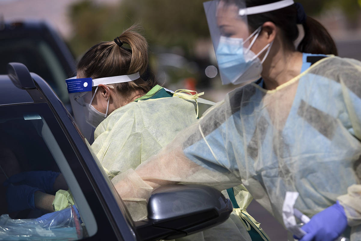 One volunteer swaps a patient's nose as another places information and a bible on their dashboa ...